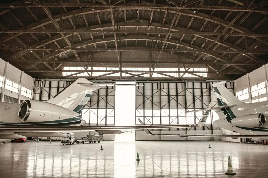 Private jets parked inside a large hangar in Paris, offering a glimpse into aviation luxury.