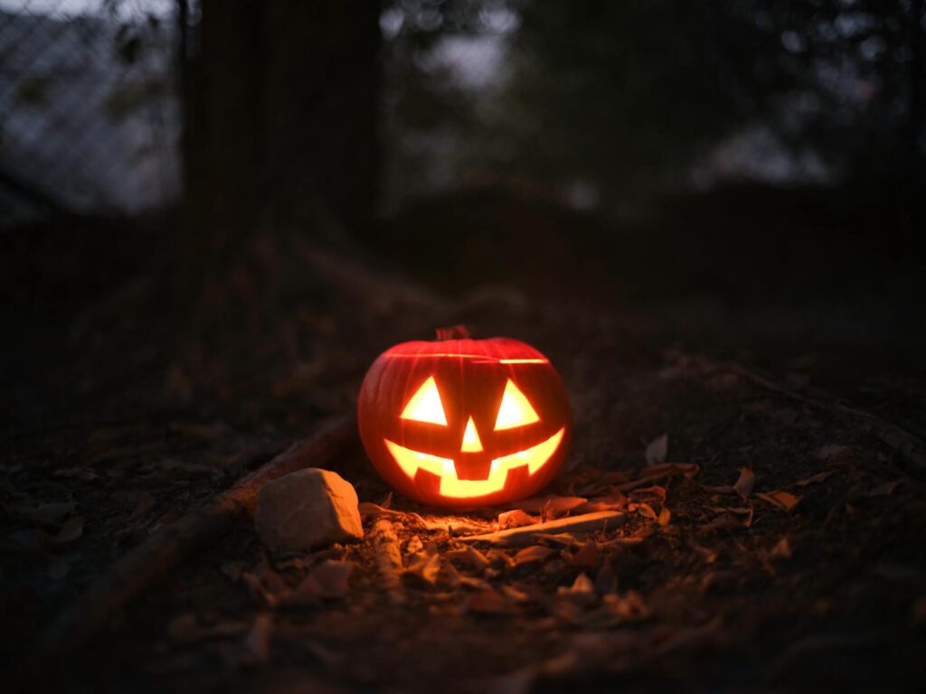 Glowing jack-o'-lantern in a spooky outdoor setting, perfect for Halloween themes.