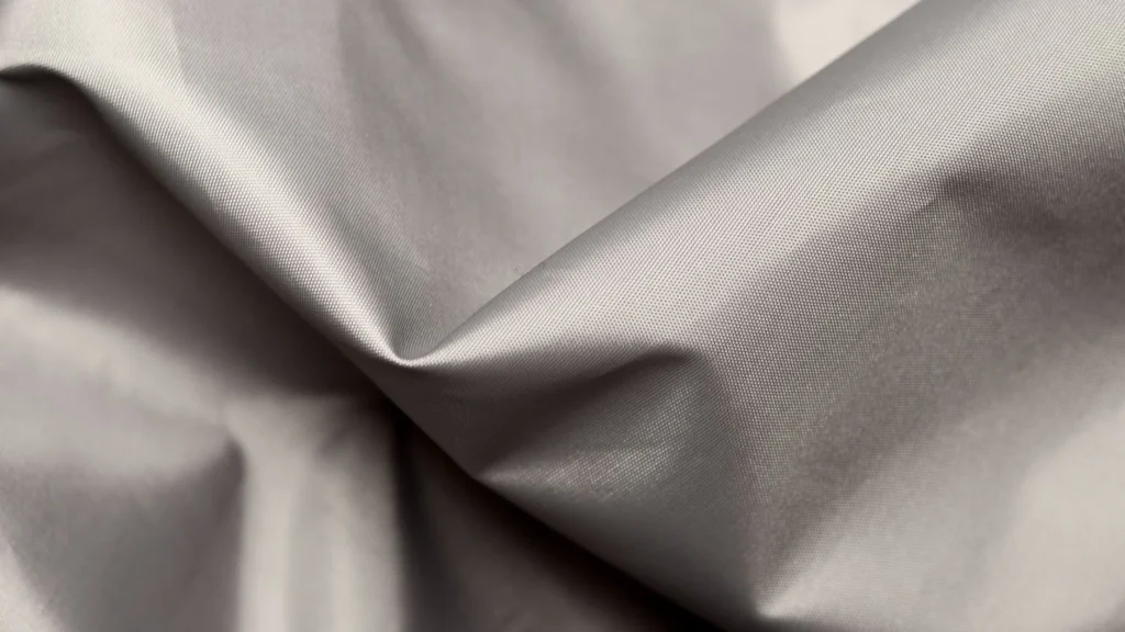 A detailed close-up of gray silk fabric showcasing its smooth texture and elegant folds.