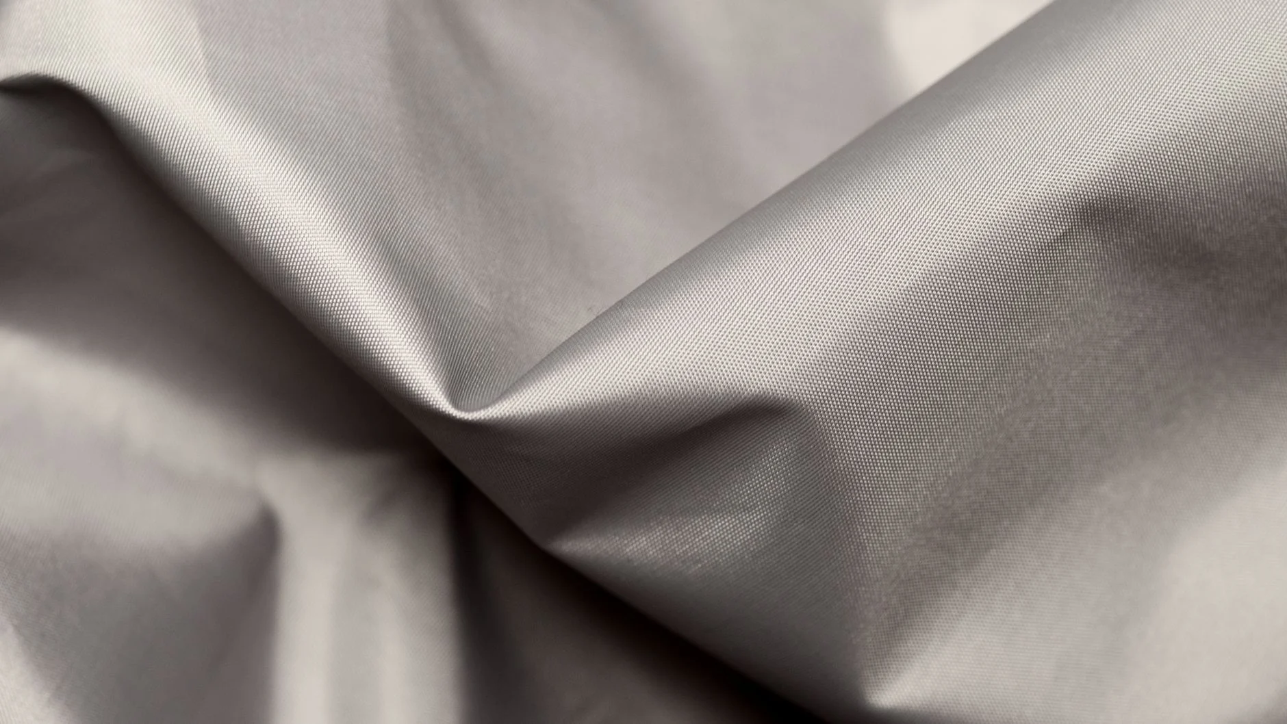 A detailed close-up of gray silk fabric showcasing its smooth texture and elegant folds.