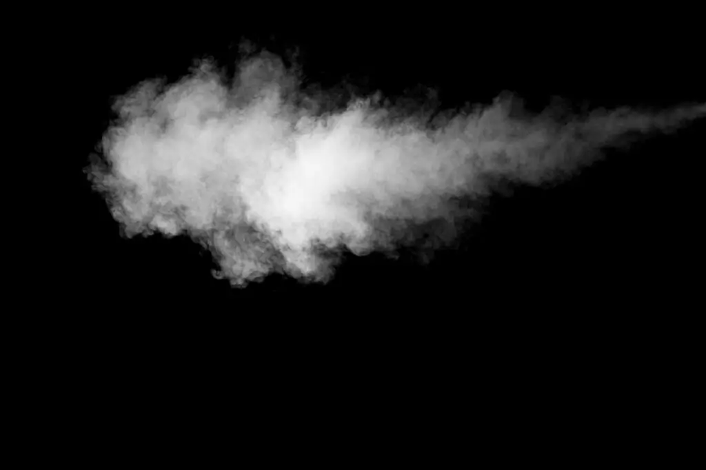 A striking black and white image of a smoke plume against a dark backdrop, highlighting texture and form.