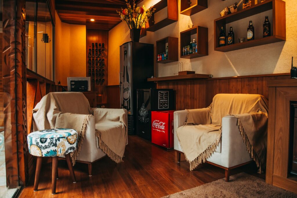 Charming lounge area featuring elegant armchairs, wooden shelving, and ambient lighting.