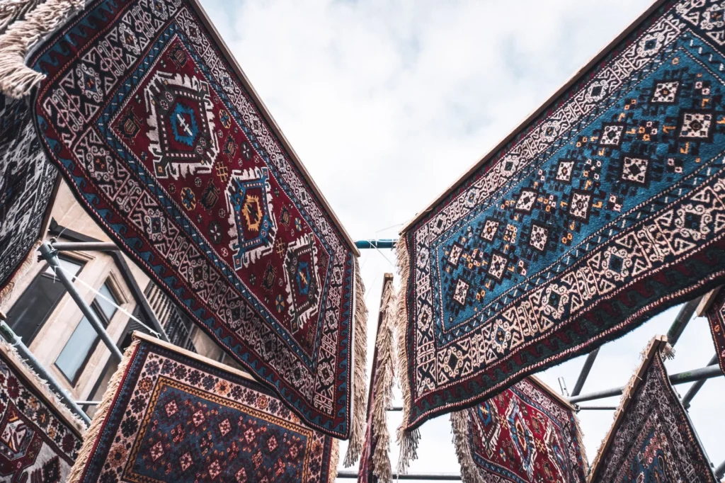 Traditional Azerbaijani rugs displayed outdoors, showcasing intricate designs and vibrant colors.