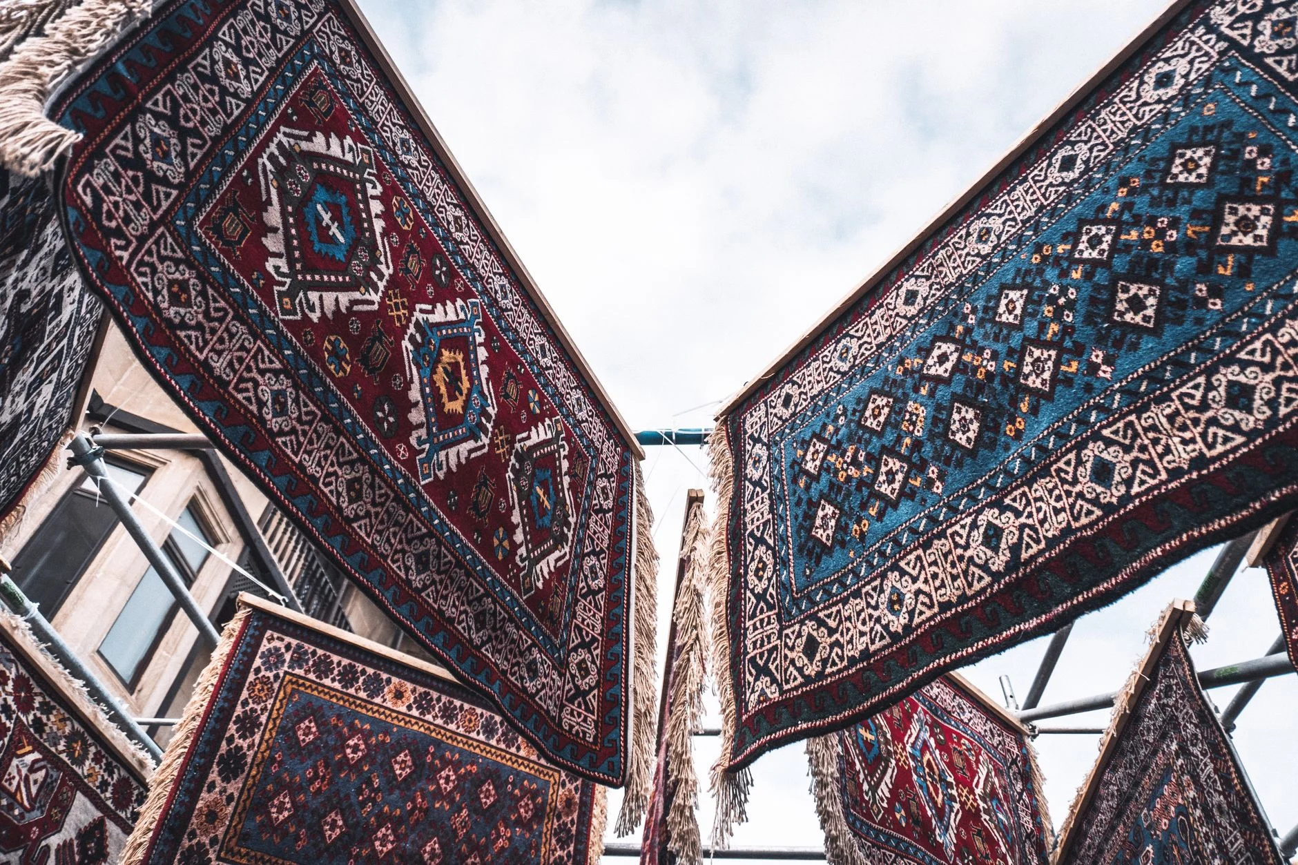Traditional Azerbaijani rugs displayed outdoors, showcasing intricate designs and vibrant colors.