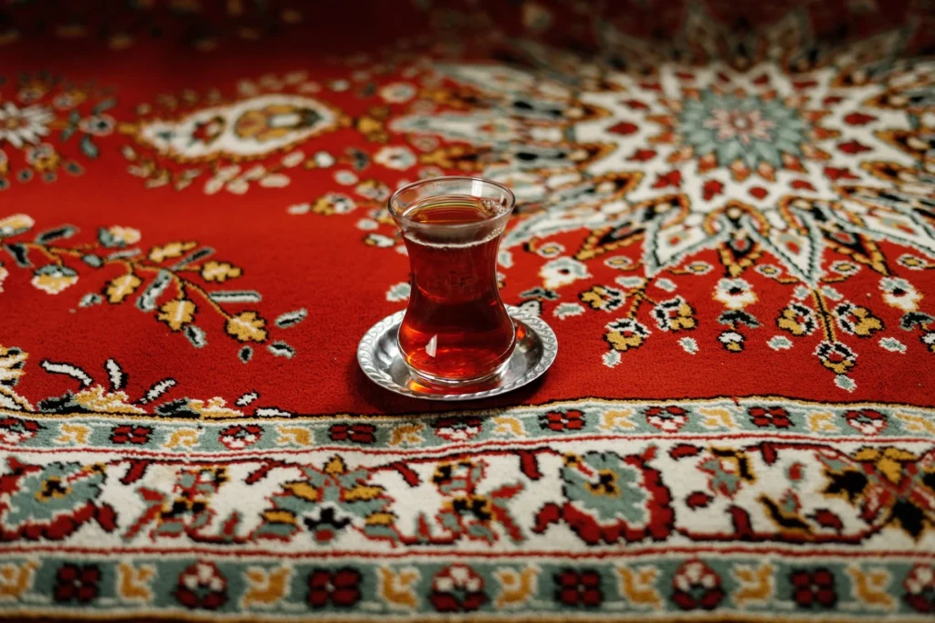 A traditional Turkish tea glass on a vibrant, decorative carpet. Captures the essence of Middle Eastern hospitality.