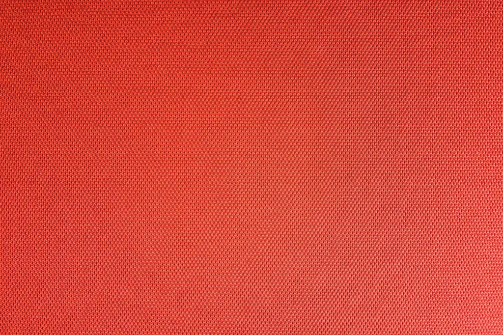 Top view of textured backdrop representing resistant bright red seamless textile with dry uneven surface