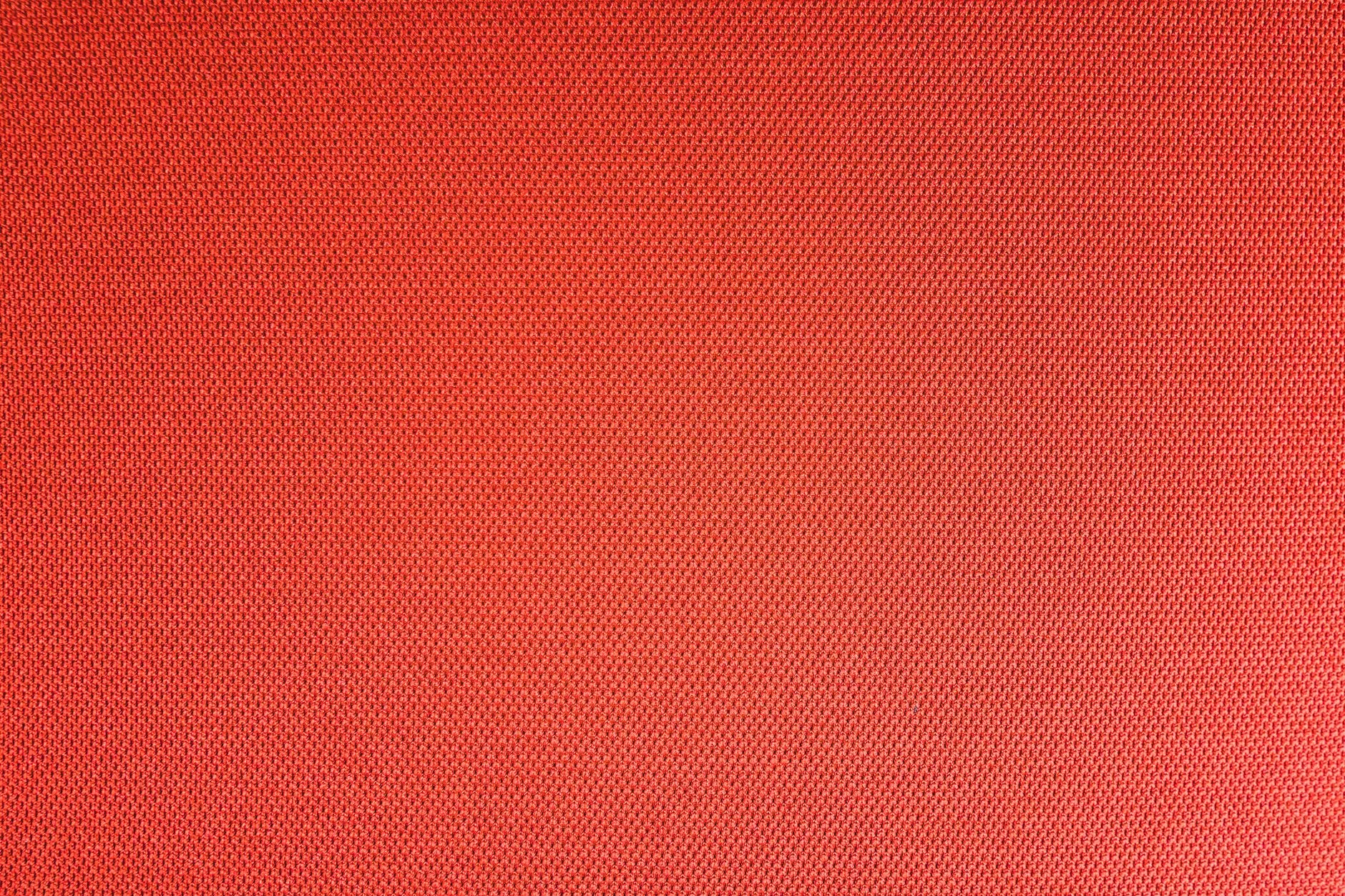 Top view of textured backdrop representing resistant bright red seamless textile with dry uneven surface