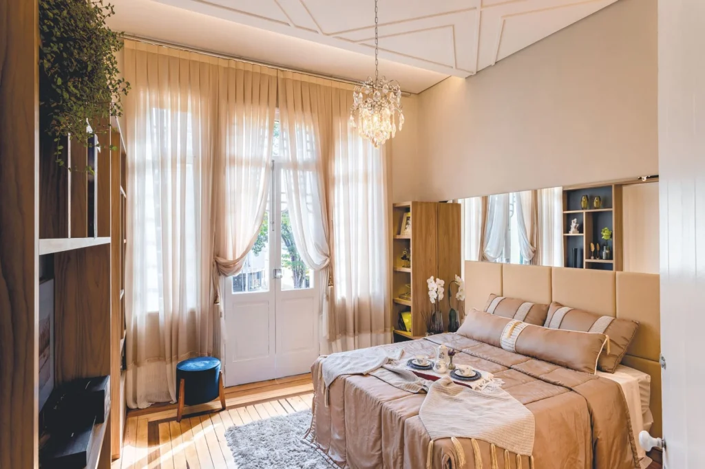 Cozy bedroom with elegant decor, soft lighting, and breakfast spread on bed, perfect for relaxation.