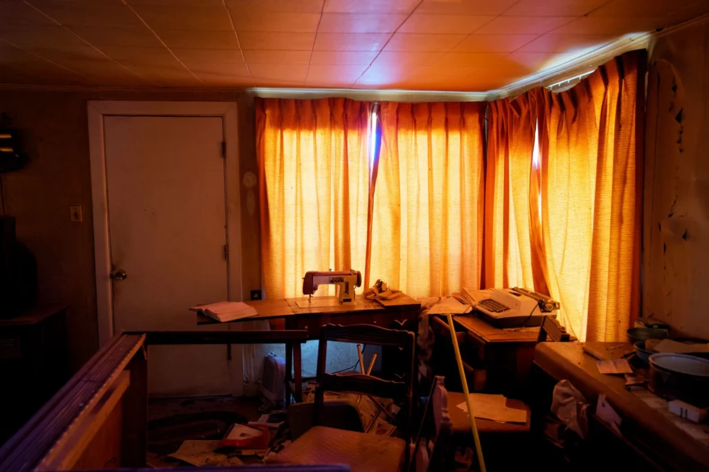 A vintage room bathed in warm light, featuring a sewing machine and typewriter.