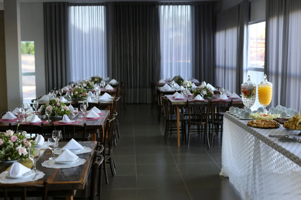 A beautifully arranged dining room with tables set for an event and a buffet table with refreshments.