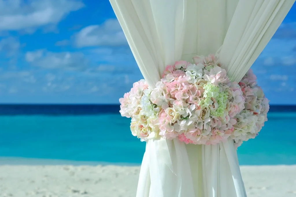 Elegant wedding setup with floral decoration on a tropical beach.
