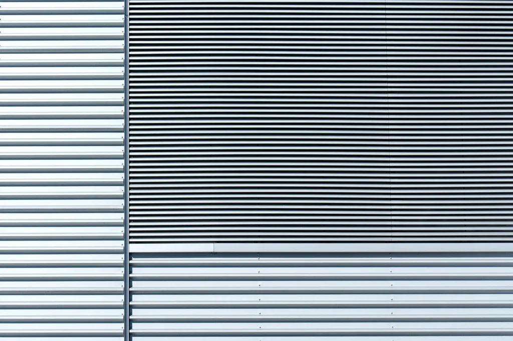 Close-up of an aluminum wall showcasing a minimalist design with horizontal stripes and metallic texture.