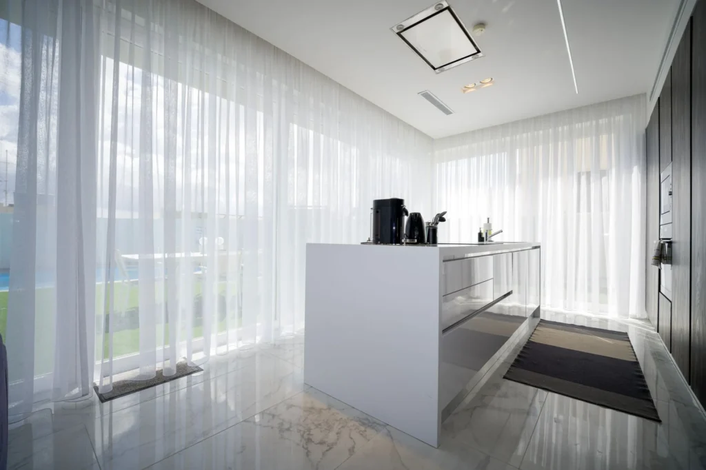 Bright modern kitchen with sheer curtains in a luxury villa located in St. Julian's, Malta.