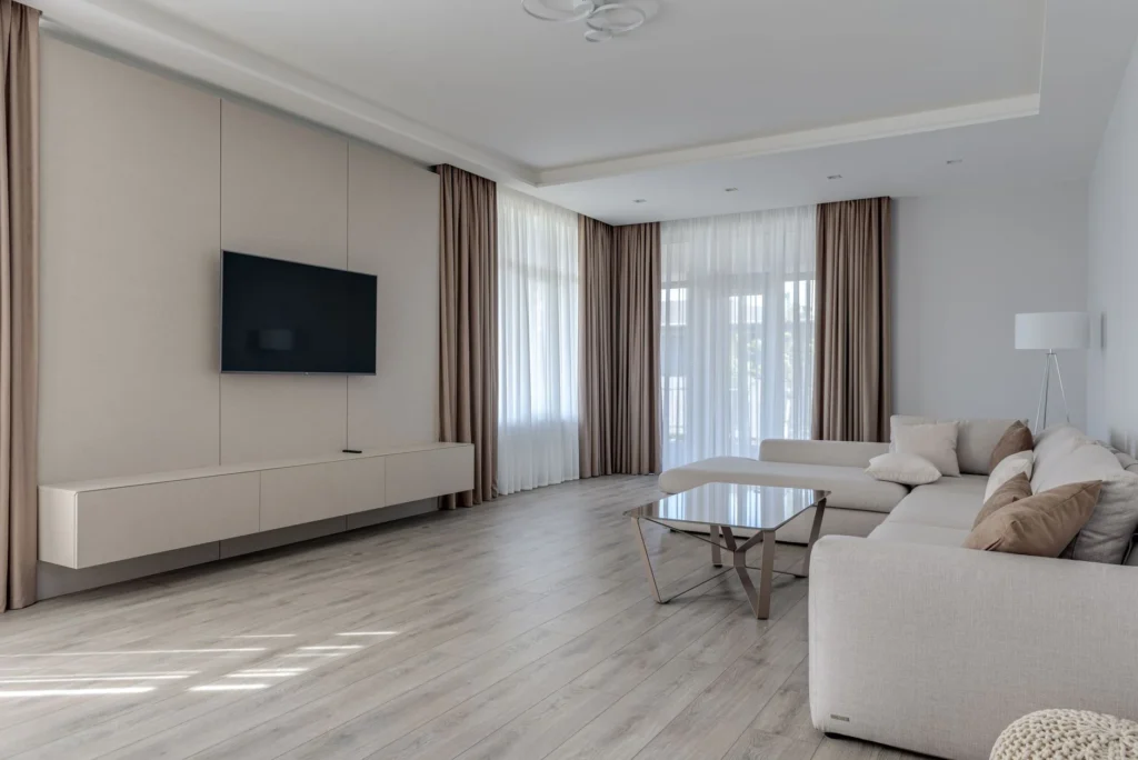 Interior of contemporary lounge zone with comfortable soft couch against TV set in room with minimalist style