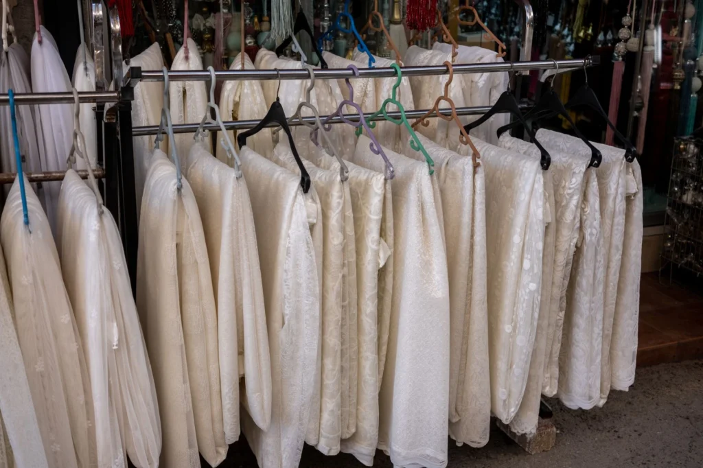 White textiles elegantly displayed on hangers in a charming İzmir boutique shop.