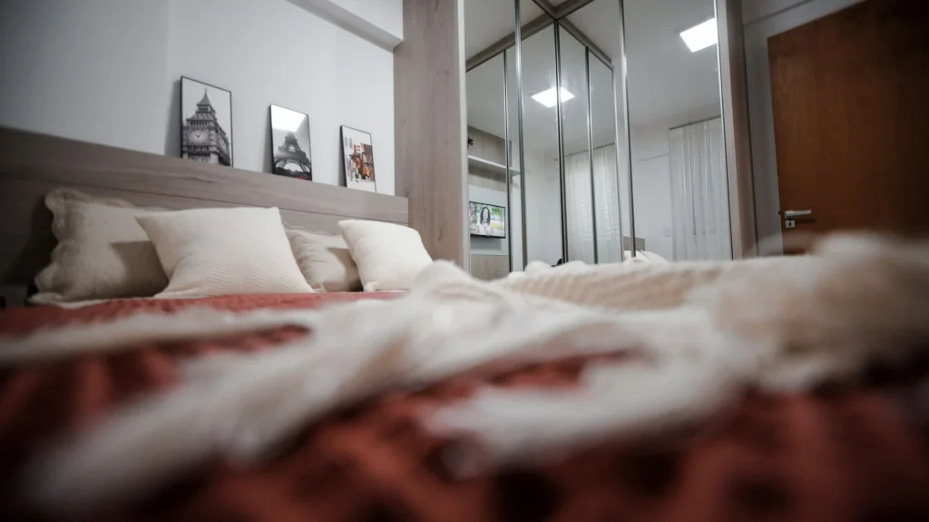 A modern bedroom featuring cozy decor and elegant furniture with a warm atmosphere.