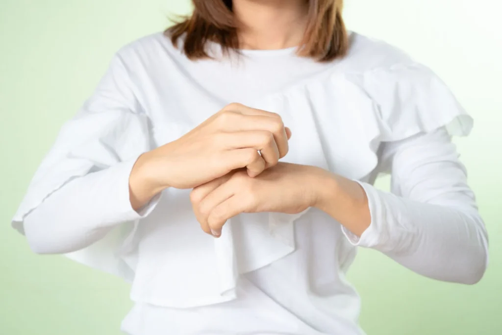 Close-up of a woman in a white blouse gesturing with her hands; soft focus on gesture.