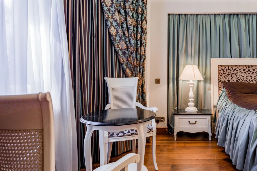 Cozy bedroom scene featuring elegant furniture with intricate patterns and luxurious drapes.