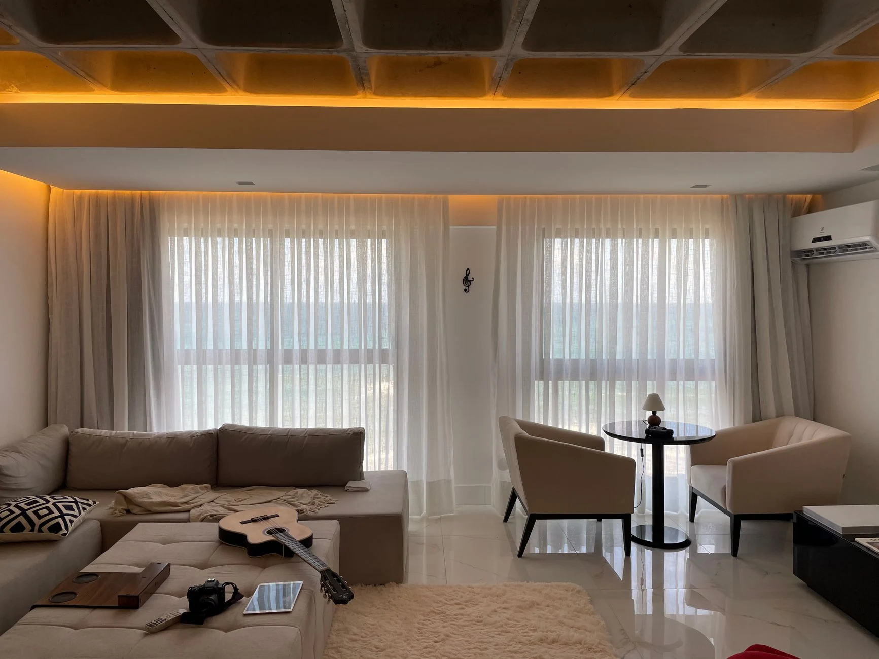 Contemporary living room with a cozy and elegant design featuring soft lighting, a couch, and a coffee table.
