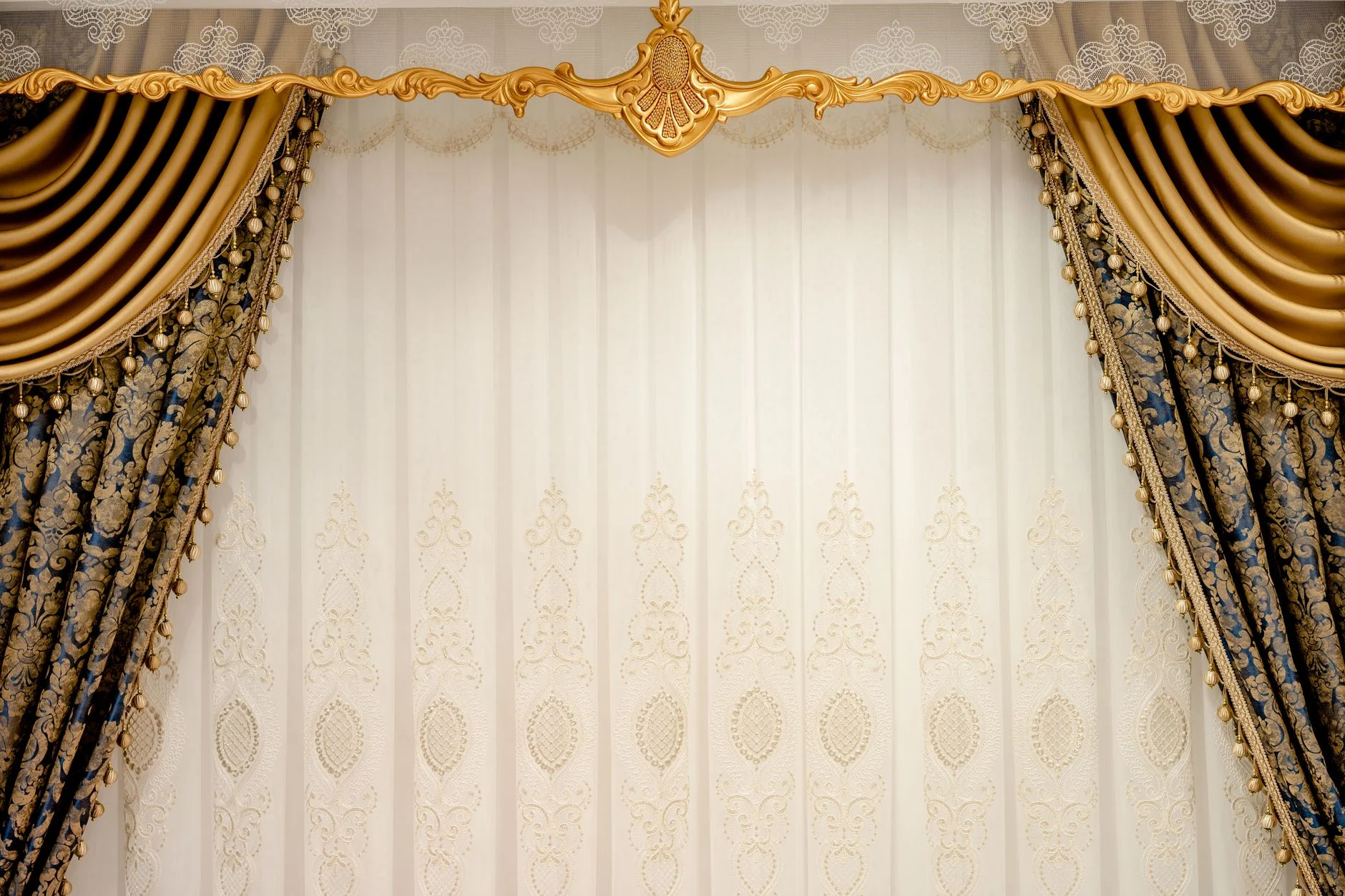 Elegant gold and blue drapes with intricate patterns create a luxurious setting.