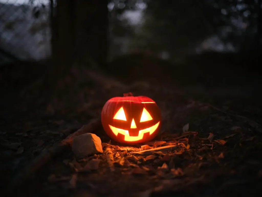 Glowing jack-o'-lantern in a spooky outdoor setting, perfect for Halloween themes.